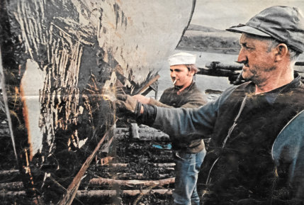 Remi Hugues (Raymond) Goyetche of Arichat, NS (on the right) with Napoleon DeCoste scraping "Bunker-C Oil" off the bottom of a boat following the sinking of the  Liberian registered tanker the Arrow in Chedabucto Bay (1970)